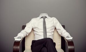 An empty shirt, pants, and tie in a chair at work