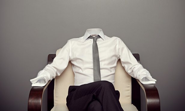 An empty shirt, pants, and tie in a chair at work