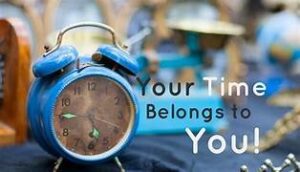 Old-fashioned. blue alarm clock with the words "your time belongs to you" next to it on the right, with a blurred background. 